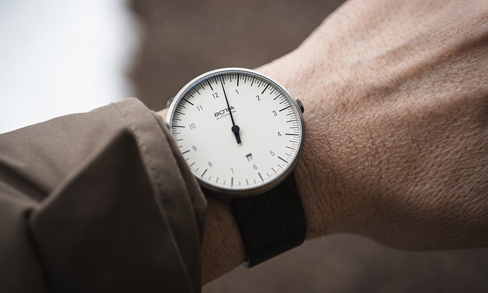 BOTTA UNO Automatik als Armbanduhr. Das klare weiße Zifferblatt mit einem schwarzen Zeiger macht das Prinzip der Einzeigeruhr sichtbar, das eine entspannte Ablesbarkeit ermöglicht. Das Titan-Gehäuse ist schlank und elegant. Diese Automatikuhr mit zuverlässigen Sellita  Automatikwerk, kratzfestem Saphirglas und edler Verarbeitung ist nicht nur eine Designuhr, sondern ein Statement für Individualität. Wer eine Armbanduhr mit einem Zeiger kaufen oder bestellen möchte, findet hier ein modernes Original.
