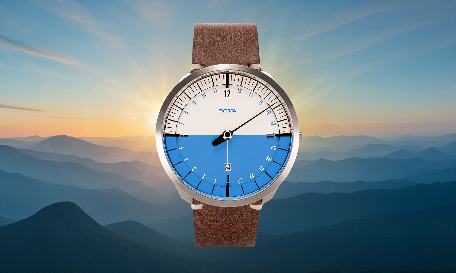 Vor der Kulisse eines Sonnenaufgangs über Berggipfeln erscheint die BOTTA UNO 24 Your Time Azur Quarzuhr. Diese hochwertige 24-Stunden Uhr mit einem Zeiger zeigt den gesamten Tagesverlauf in blau-weißer Tag-Nacht-Darstellung sonnen¬synchron an. Als Einzeigeruhr verbindet sie minimalistisches Design mit der Präzision eines Titan-Quarzwerks. Eine außergewöhnliche Armbanduhr mit einem Zeiger – jetzt kaufen oder bestellen und Zeit neu erleben.